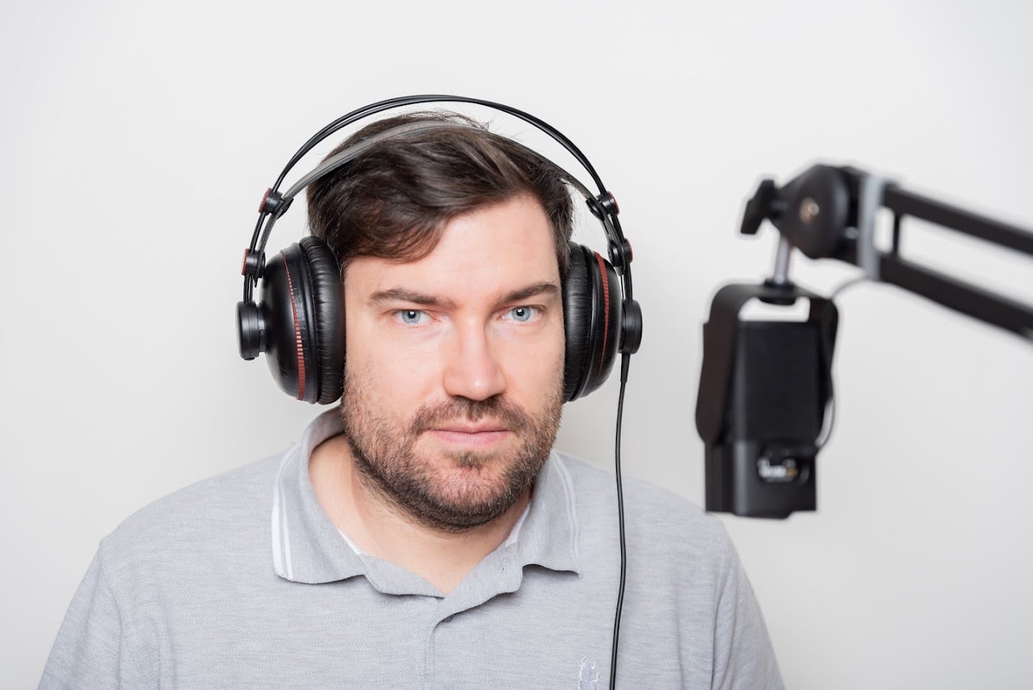 Marek Adler se sluchátky u podcastového mikrofonu